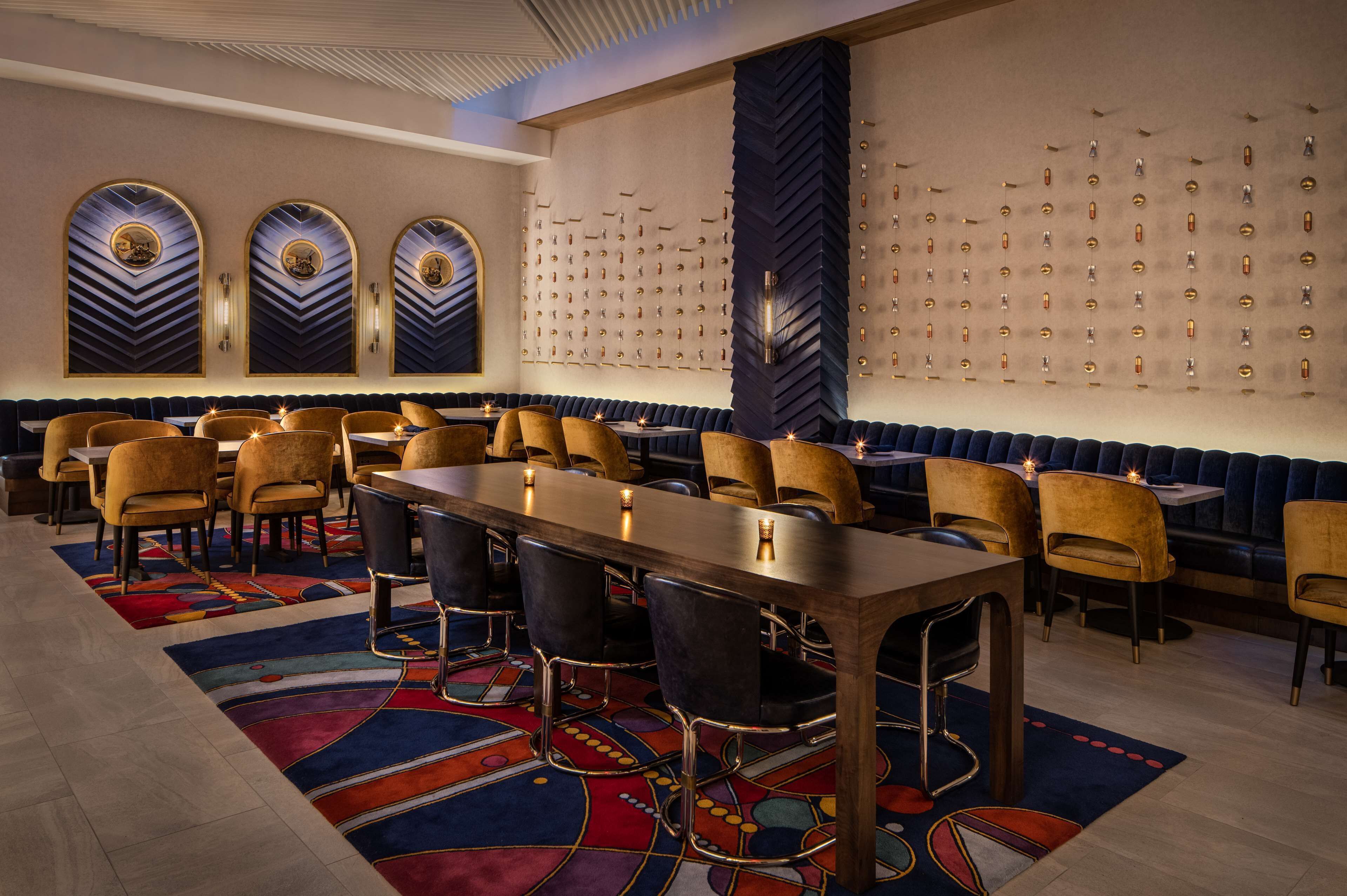 A conference room with a long table, multiple chairs, and a patterned carpet.