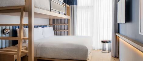 A bunk bed room with a wooden ladder, a small stool, and a TV on the wall.