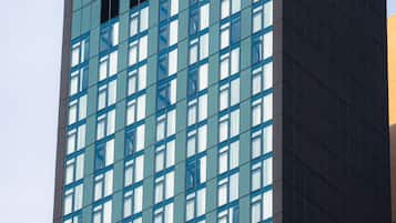 A tall building with a grid of windows and a dark facade.