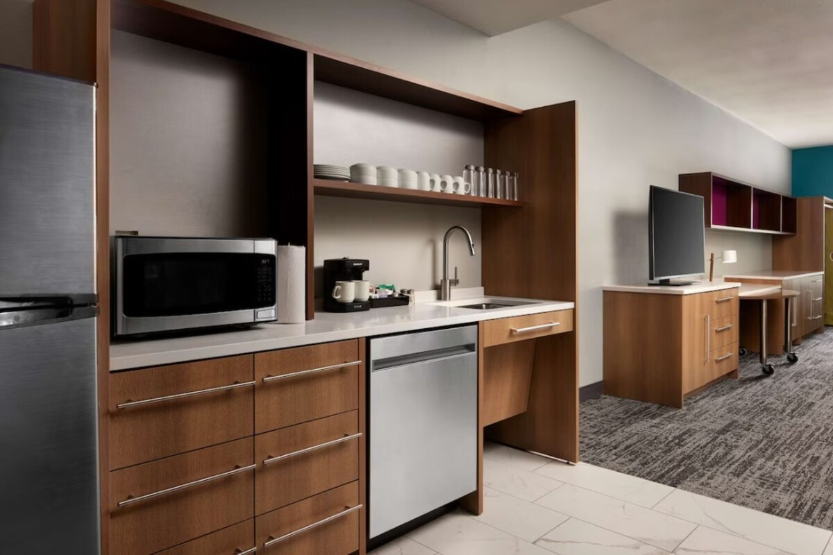A modern kitchen with a microwave, coffee maker, and dishwasher.