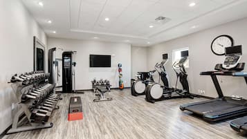 A gym with treadmills, elliptical machines, and weight equipment.