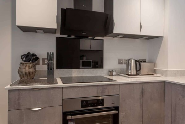 A modern kitchen with a built-in stove, microwave, and oven. - Modern 1BR Stay | Stay Zeni, Ouse Court York (York)