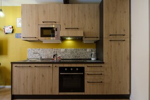 Departamento, 1 habitación | Cocineta privada | Refrigerador con congelador, microondas, horno y parrilla de estufa 