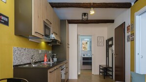 A compact kitchen with wooden cabinets, a tiled backsplash, and a modern sink. - Casa del sole by Studio Vita (Bologna)