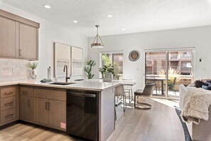 Enjoy meals in the spacious kitchen and dining area with a central island, dishwasher, and dining table with chairs.