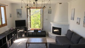 Ein Wohnzimmer mit Kamin, Fernseher und einer Couch.