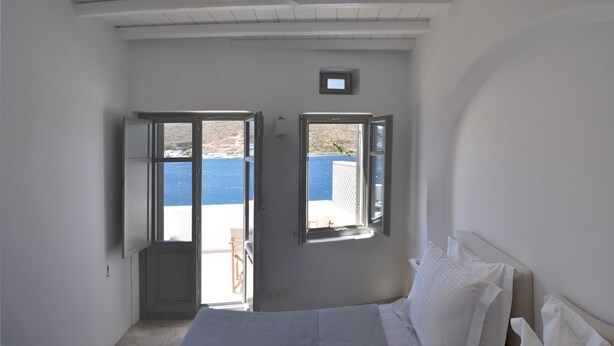 A bedroom with two open windows, a bed, and a small desk. - Amorgos the olive garden above the sea I (Katapola)