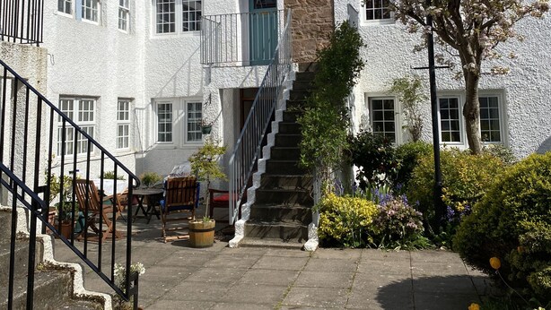 A traditional building with a stone facade, a tiled roof, and a staircase leading to the entrance. - The Crail Maltings (Anstruther)