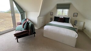 Een slaapkamer met een bed, een stoel, een raam en een radiator.