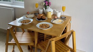 Een ontbijttafel met borden eten, een kaart en een raam met uitzicht op groen.