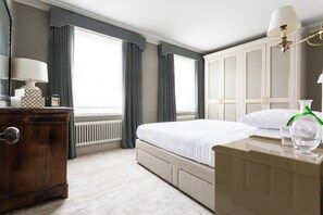 A hotel room with a bed, dresser, and a large window with curtains. - First Street III by Onefinestay (London)