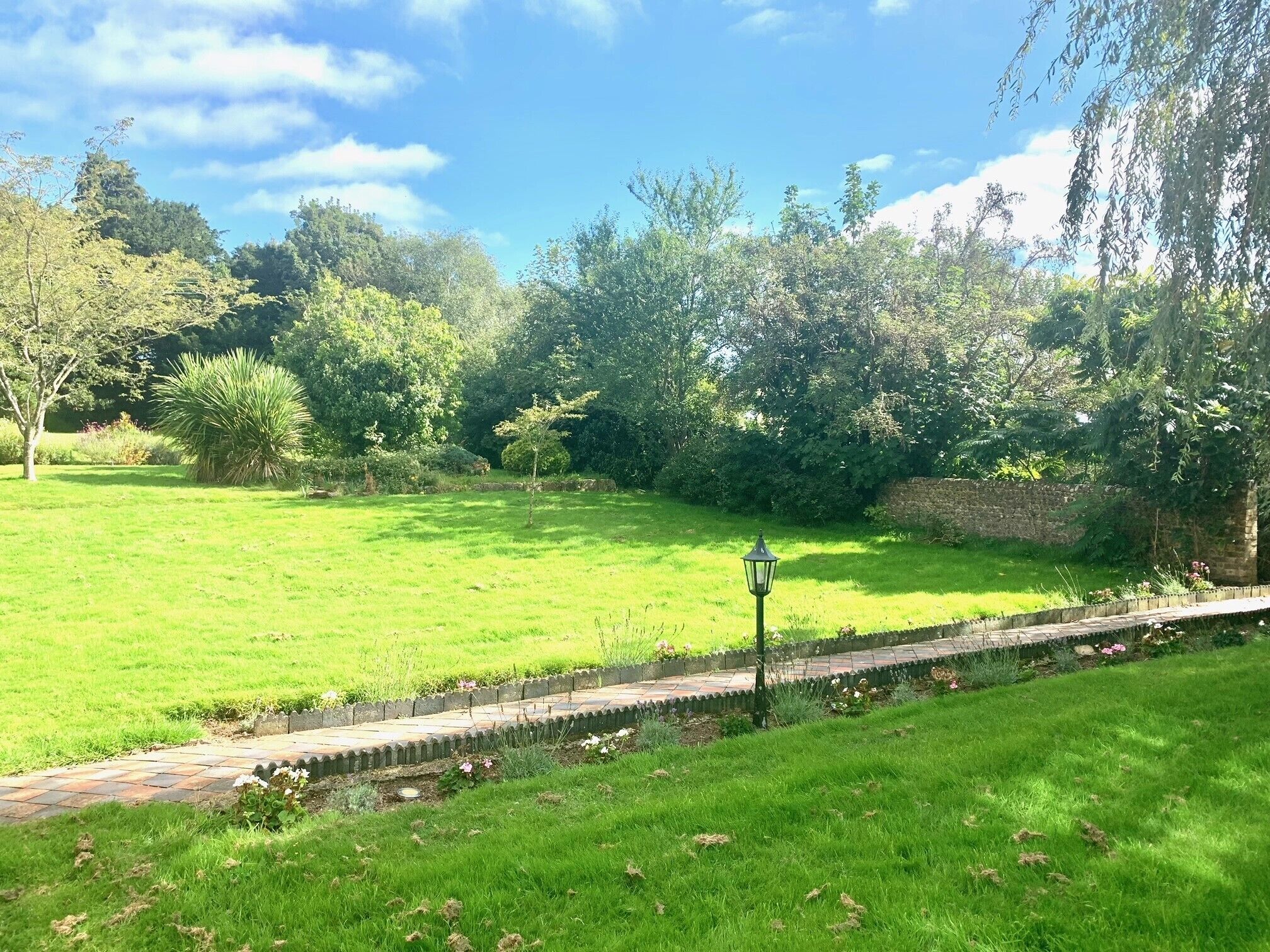 A well-maintained grassy area with a pathway and a lamppost.