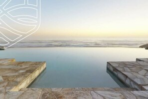An infinity pool with a view of the ocean at sunset. - BEACH FRONT CONDO, PRIVATE BEACH & AMAZING VIEWS!! (Rosarito)