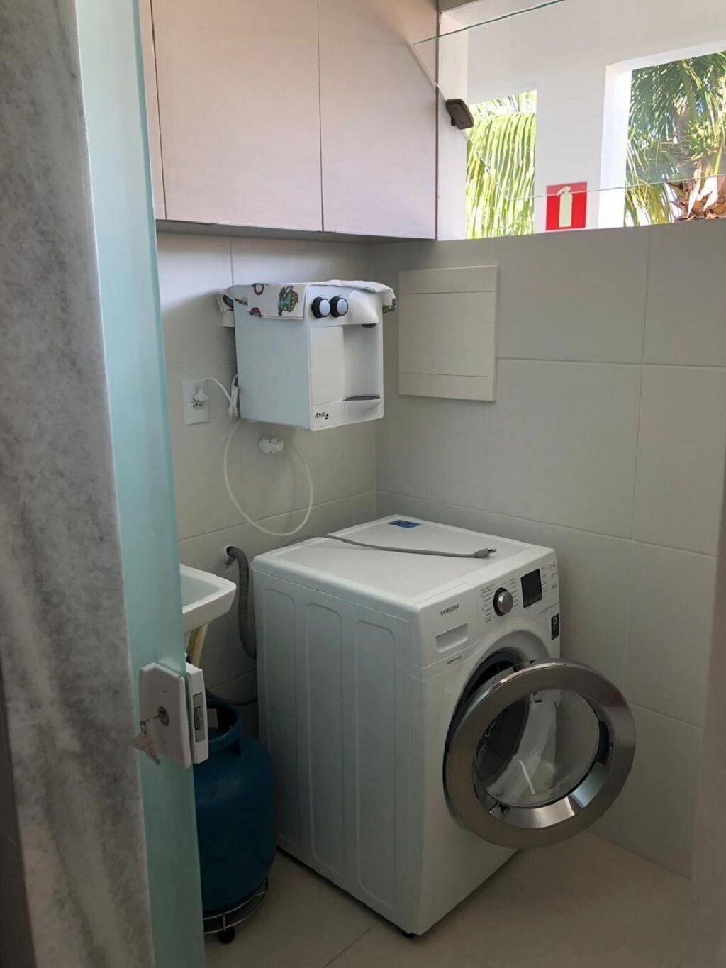 Ein kleiner Hauswirtschaftsraum mit Waschmaschine, Trockner und Warmwasserbereiter.