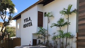 A black SUV parked in front of a building with a sign that reads "VILA, ODOIA". - Luxury apartment, 3 bedrooms (2 suites) - Praia da Espera - Itacimirim (Camaçari)