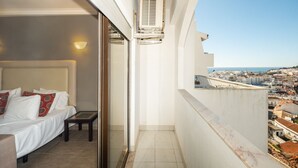 Un balcone con un letto, un comodino e vista sulla città.