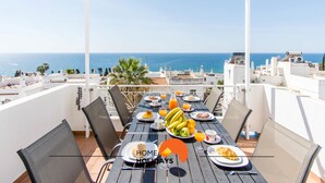 Un balcone con un tavolo apparecchiato per la colazione, vista mare.
