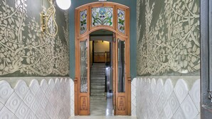 A staircase with ornate wooden doors and patterned walls.