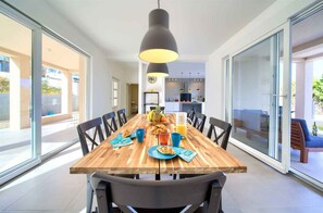 Un coin repas avec une table en bois, des chaises et une suspension.