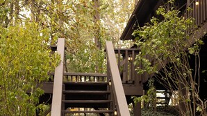 Eine von Grün umgebene Holztreppe, die zu einem Holzbauwerk führt.