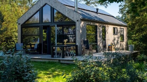 A modern house with a large glass front, a wooden deck, and a sloped roof. - Nature lodge Blaukopke, Akkrum - private jetty, sleeps 6 (Akkrum)