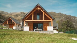 A wooden chalet with a balcony, a stone foundation, and a mountainous backdrop. - Chalet Viscos (Les Chalets du Balandrau) (Ayzac-Ost)