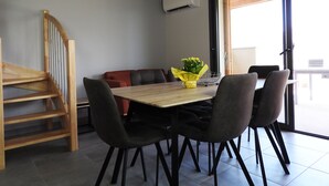 A dining area with a wooden table, black chairs, and a small yellow flower arrangement. - Chalet Viscos (Les Chalets du Balandrau) (Ayzac-Ost)