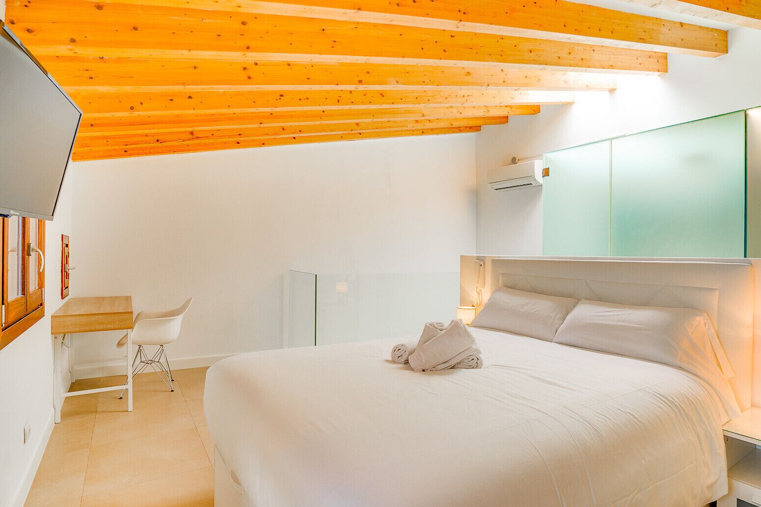 Une chambre à coucher moderne avec un grand lit, un bureau et une chaise.