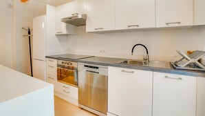 A modern kitchen with white cabinets, stainless steel appliances, and a wooden ceiling. - DUPLEX PALMA APARTMENT ETV/5551 (Palma de Mallorca)