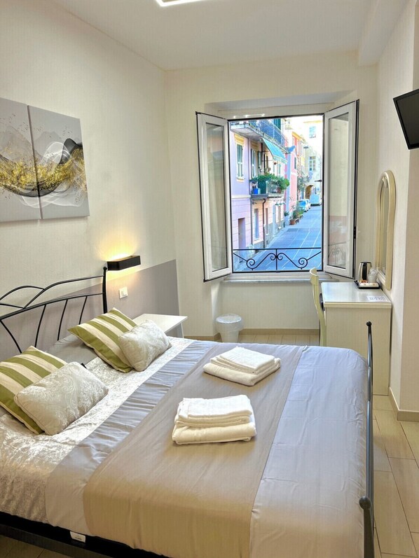 Relax in a stylish room with a large bed, bedside table, and window offering a view of the city.