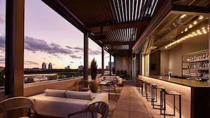 A rooftop bar with a city view, seating area, and bar counter. - AC Hotel Atlanta Perimeter (Atlanta)