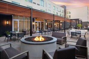An outdoor seating area with a fire pit, tables, and chairs. - Courtyard by Marriott Fresno Clovis (Clovis)