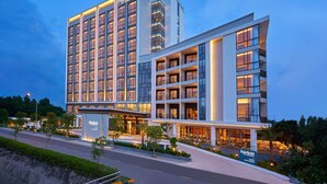 A modern hotel with multiple floors, a prominent sign, and a well-lit entrance.