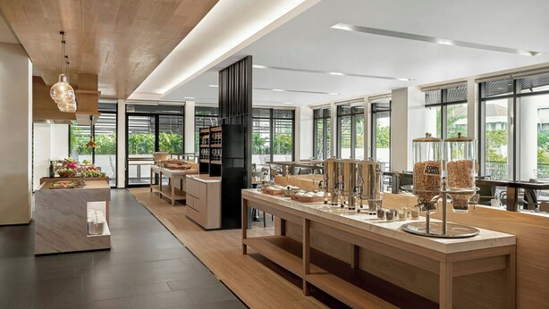 A modern kitchen with a long counter, wooden cabinets, and a central island.