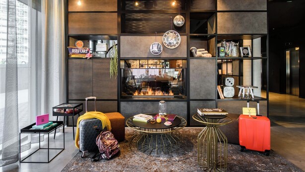 Un área lounge moderna con chimenea, asientos y una estantería.