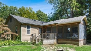 A single-story house with a front porch, a covered porch area, and a stone pathway leading to the entrance. - Union Pier Home With Hot Tub and One Block To Beach! (Union Pier)