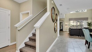 A modern interior with a staircase, a dining area, and a living room.