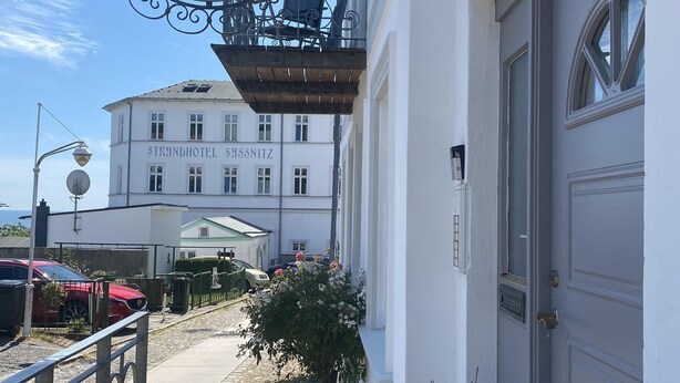 Un bâtiment sur lequel on peut lire l’inscription « Pension Villa Daheim » et « Ferienwohnungen Apartments Zimmer ».