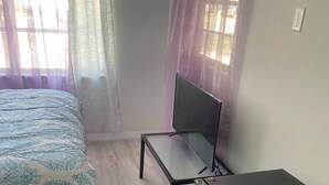 Une chambre à coucher avec un lit, un bureau et un réfrigérateur.