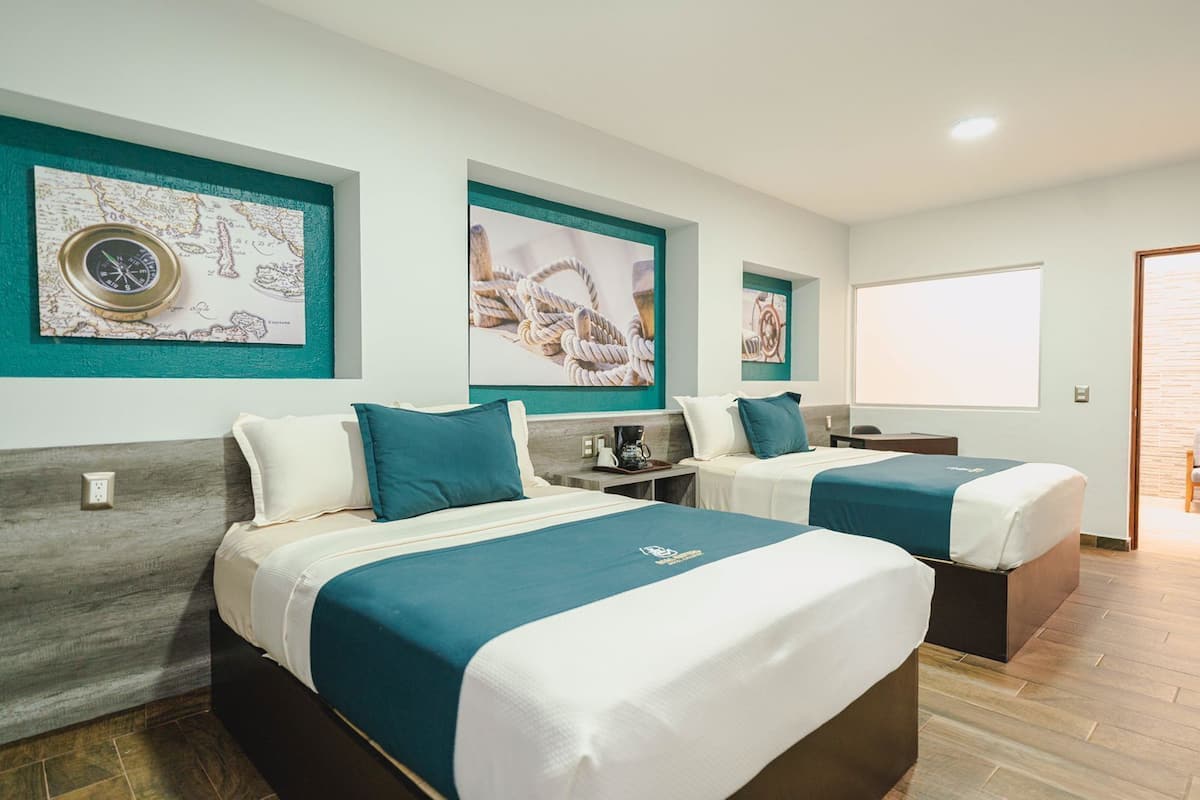 Une chambre d’hôtel avec deux lits, un bureau et une grande fenêtre.