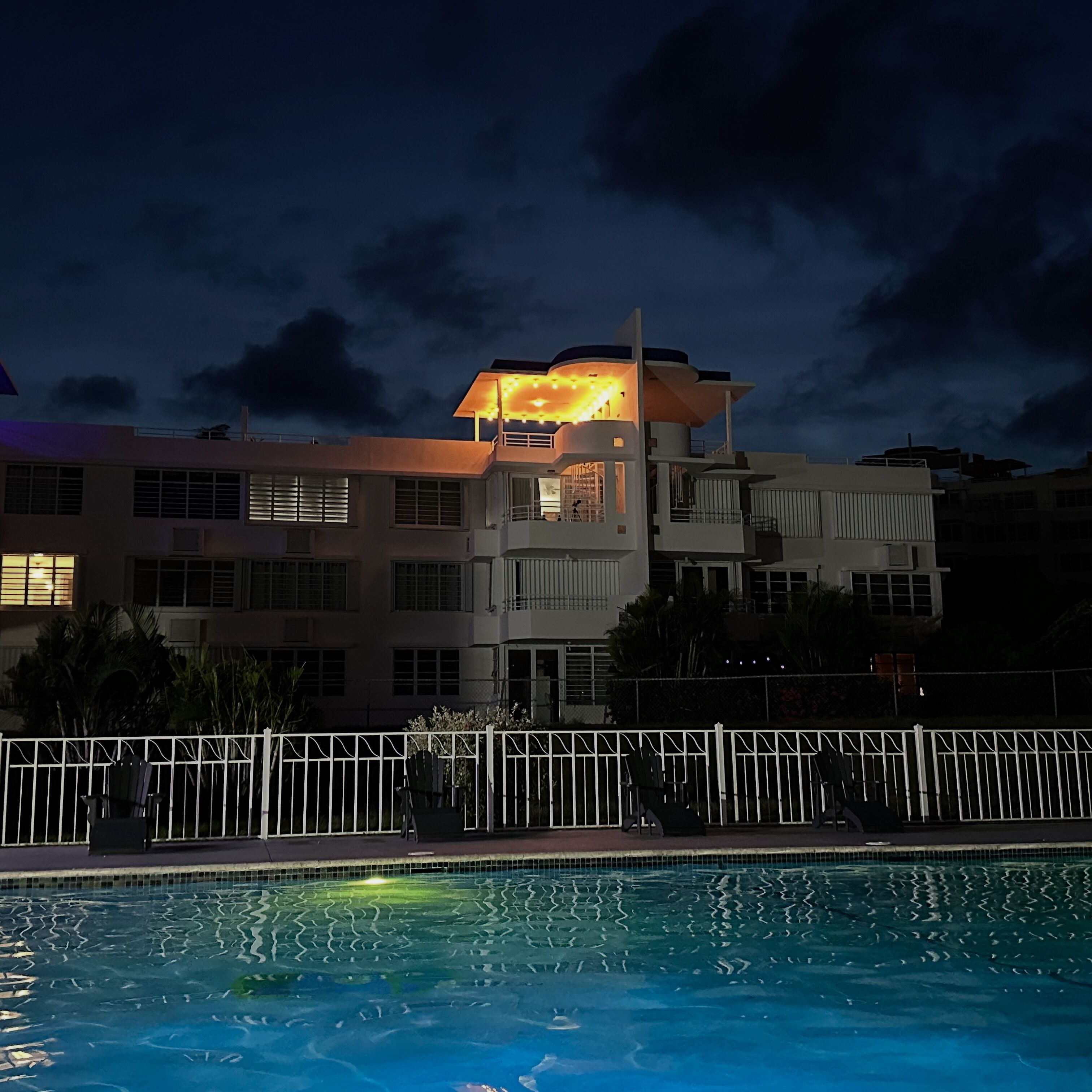 A modern building with a swimming pool in front.
