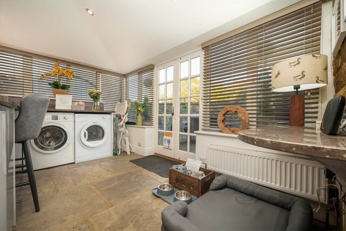 A laundry area with a washing machine, dryer, and ironing board.
