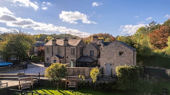 A stone building with a covered porch and a paved driveway. - Family Home | River Derwent | Hot tub | 10 guests (Darley Bridge)