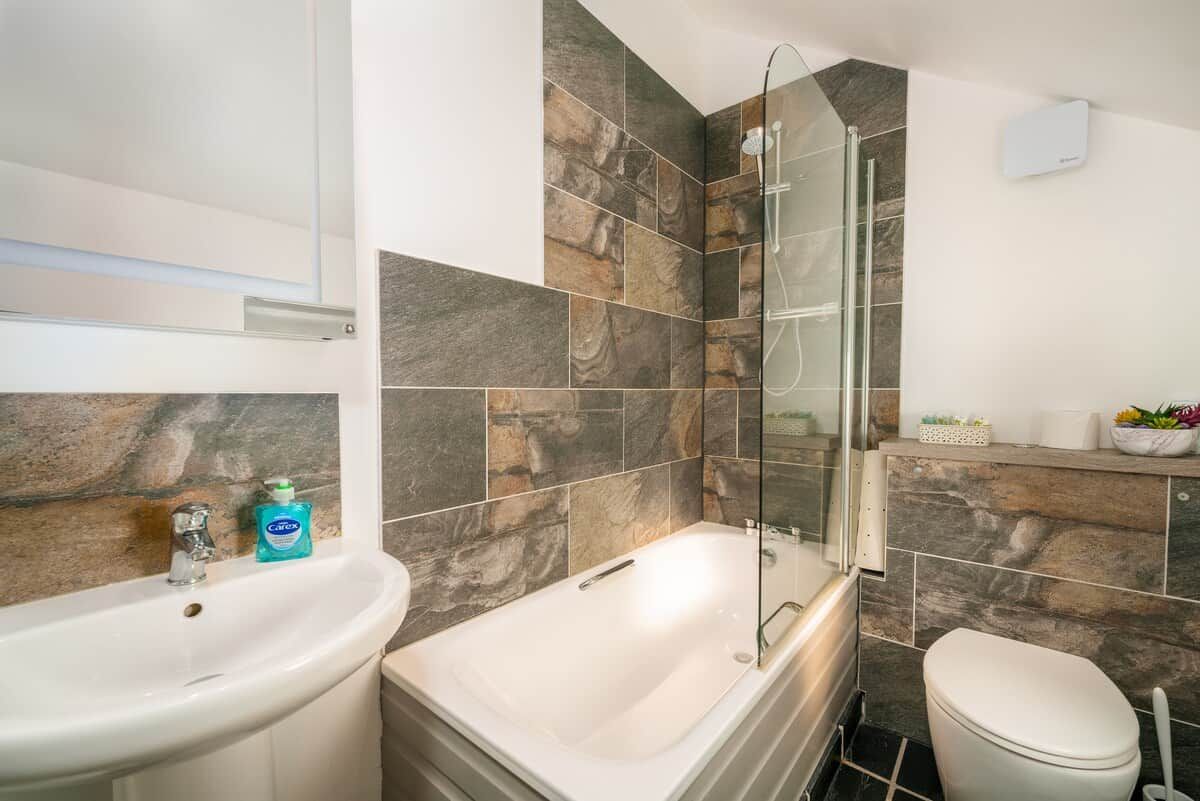 A bathroom with a bathtub, toilet, and sink.
