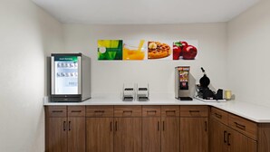 A kitchenette with a refrigerator, a coffee machine, and a microwave. - Quality Suites Wildwood - The Villages (Wildwood)