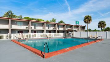 Una piscina al aire libre, tumbonas