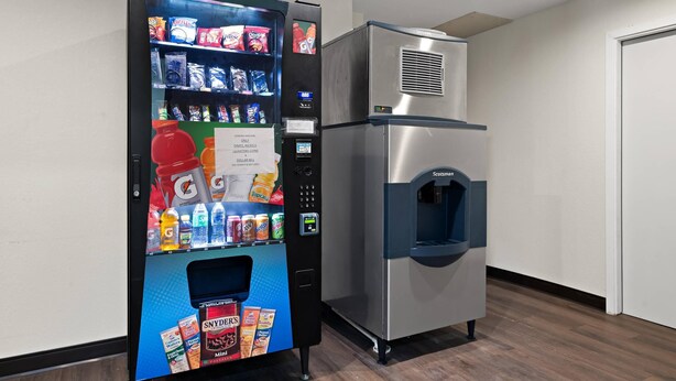 Una máquina expendedora y un dispensador de agua en una habitación de hotel.