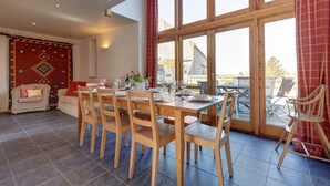 A dining area with a wooden table set for six, surrounded by wooden chairs. - Workshop - sleeps 8 guests  in 4 bedrooms (Holt)