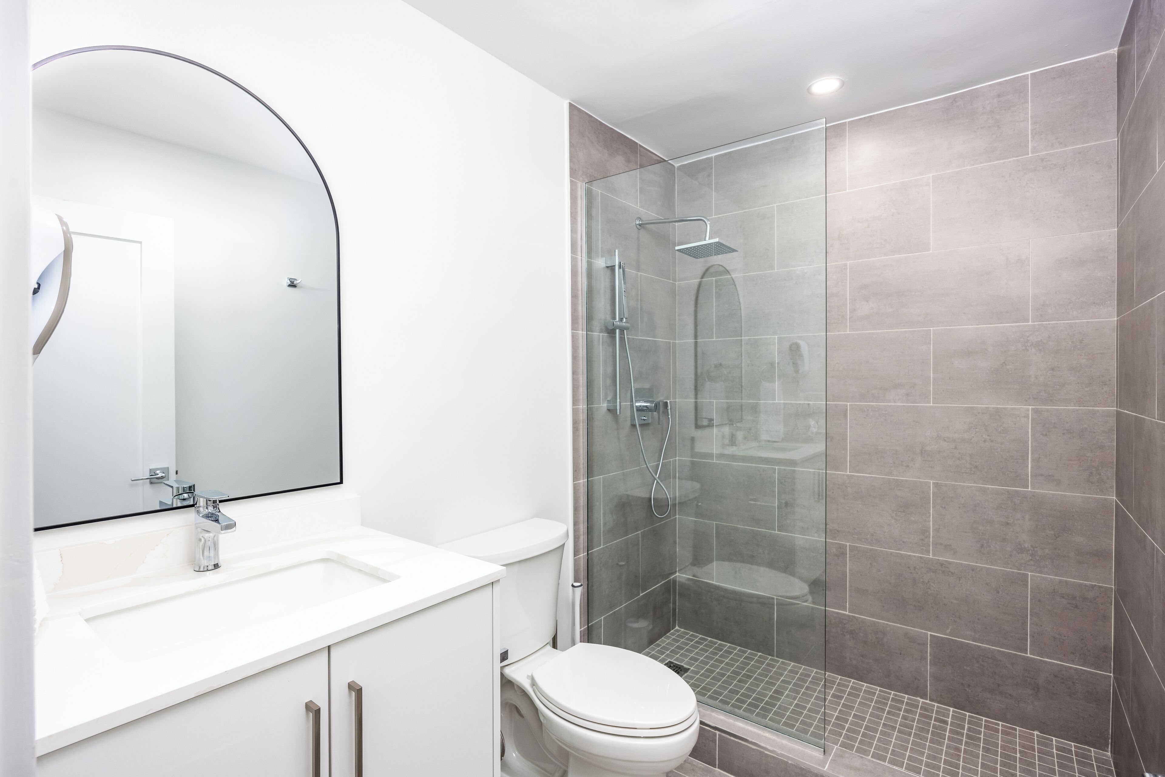 Ein modernes Badezimmer mit Waschbecken, Toilette und einer Duschkabine.