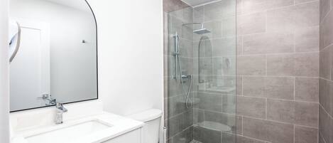 Ein modernes Badezimmer mit Waschbecken, Toilette und einer Duschkabine.